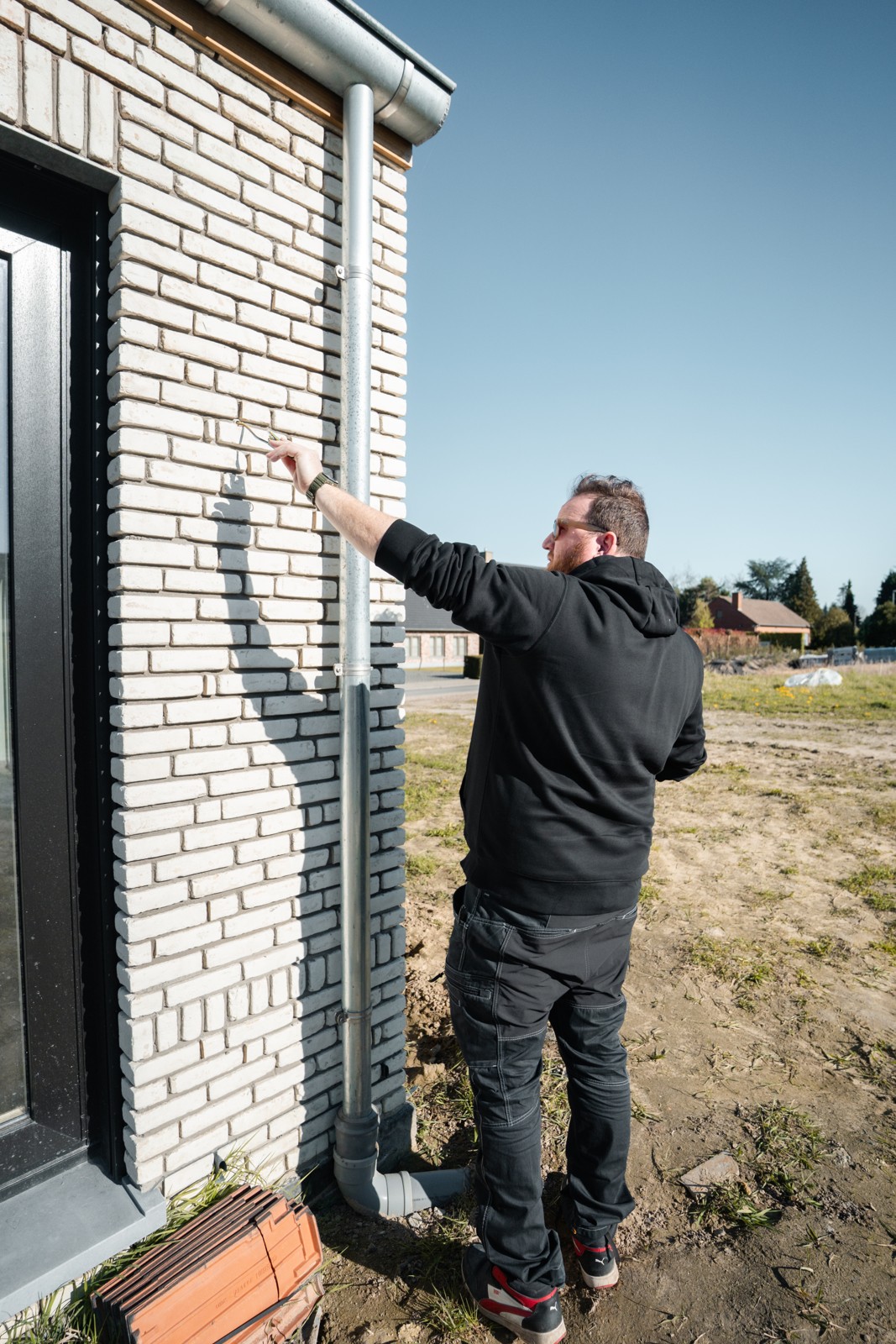 Een E-Ctrl-agent bekijkt een installatie aan de buitengevel