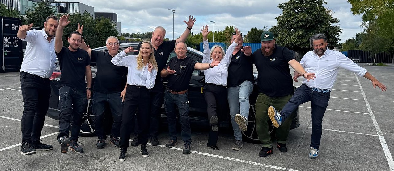 Het volledige E-Ctrl-team poseert enthousiast bij de bedrijfswagens