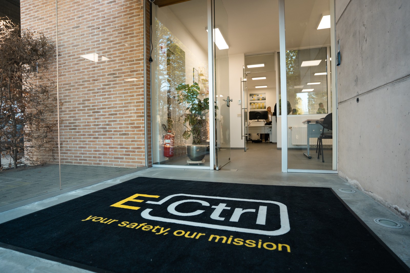 De E-Ctrl-mat aan de glazen toegangsdeur van ons kantoor